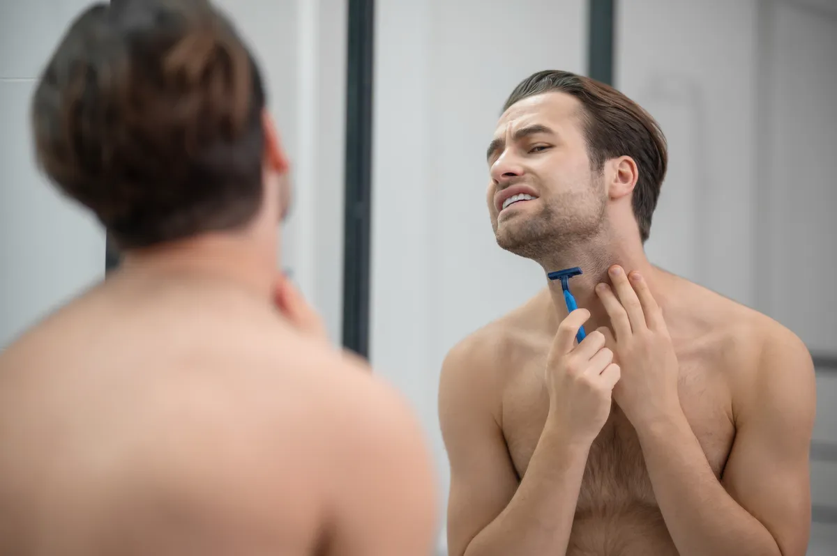Mężczyzna goli się patrząc w lustro