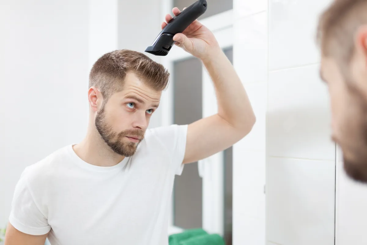 Mężczyzna strzyże włosy na skroniach
