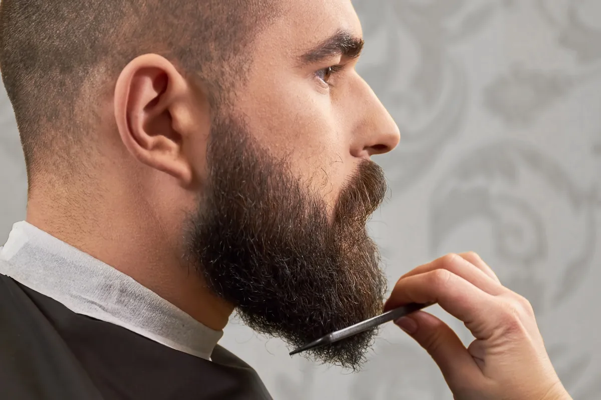 Mężczyzna rozczesuje brodę grzebieniem