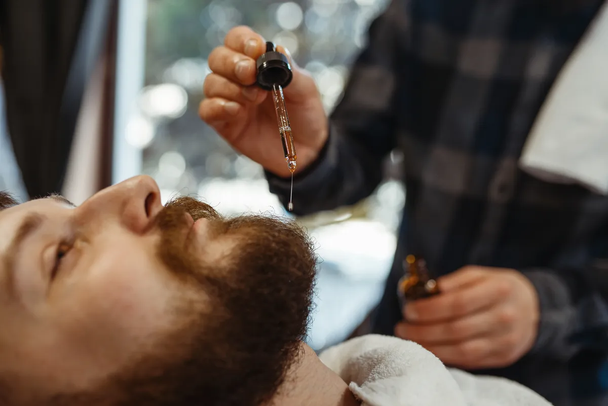 Mężczyzna rozczesuje brodę grzebieniem