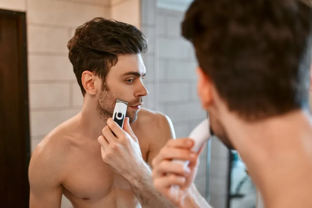 Mężczyzna goli brodę trymerem